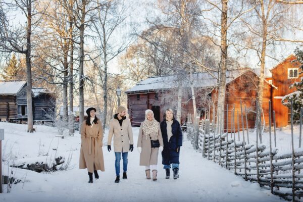 Fyra gäster promenerar på Skansen, snö, sol, jul